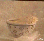 a bowl of food is being cooked in a microwave with smoke coming out of it
