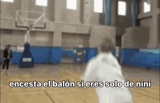 a blurred image of a basketball court with the words " encesta el balon si eres solo de nini "