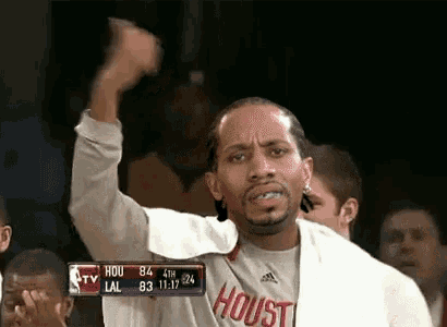 a man wearing a houston shirt is raising his fist in the air during a basketball game