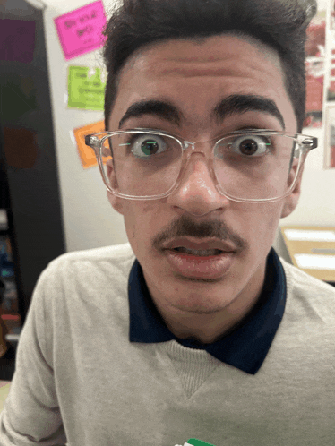 a man with glasses and a mustache is making a face