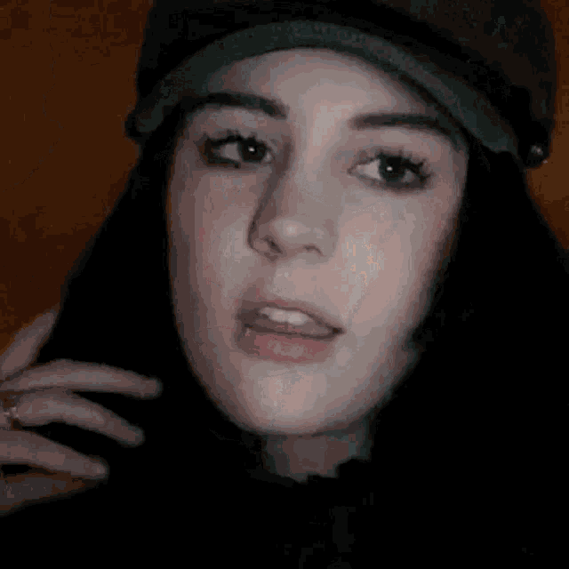 a close up of a woman wearing a hat and a butterfly on her face .