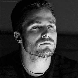a black and white photo of a man with a beard and mustache looking up .