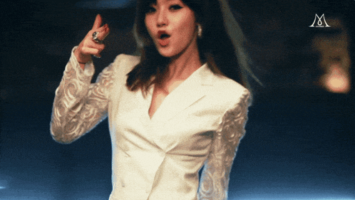 a woman in a white jacket has the letter m above her head