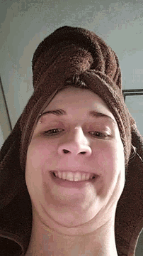 a woman with a towel wrapped around her head makes a funny face