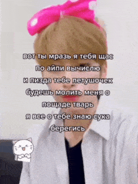 a man with a pink bow on his head is wearing a white shirt and a black shirt .