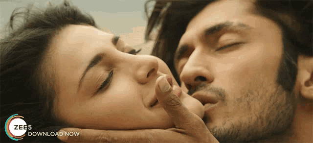 a man kissing a woman on the forehead with a zee5 download now advertisement in the background