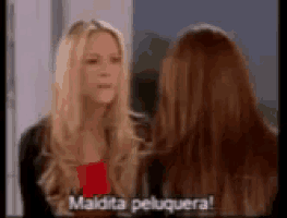 two women are standing next to each other and one of them is saying maldita peluquera .