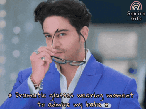 a man in a blue suit is wearing glasses with a caption that says " dramatic glasses wearing moment to admire my babe "