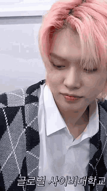 a young man with pink hair is wearing a plaid jacket and white shirt .