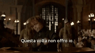 a man is standing in front of a crowd with the words questa volta non offro io written on the bottom .