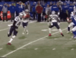 a group of football players are playing a game on a field . one of the players has the number 20 on his jersey .
