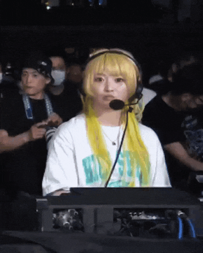 a woman with yellow hair is wearing headphones and a shirt that says ' a ' on it