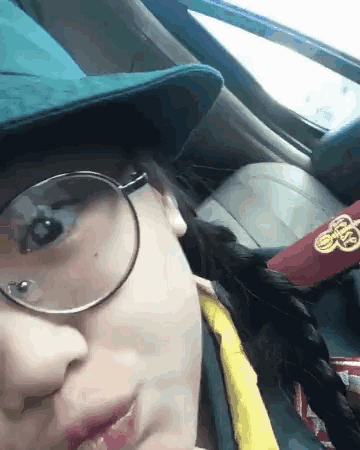 a girl wearing glasses and a hat has a badge on her uniform that says scout