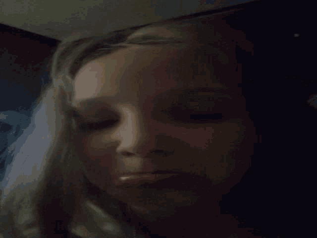 a close up of a person 's face with a dark background