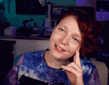 a woman with red hair and blue eyes is smiling