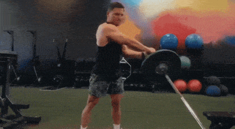 a man is lifting a barbell in a gym while wearing shorts