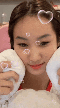 a close up of a woman 's face with bubbles in the shape of hearts