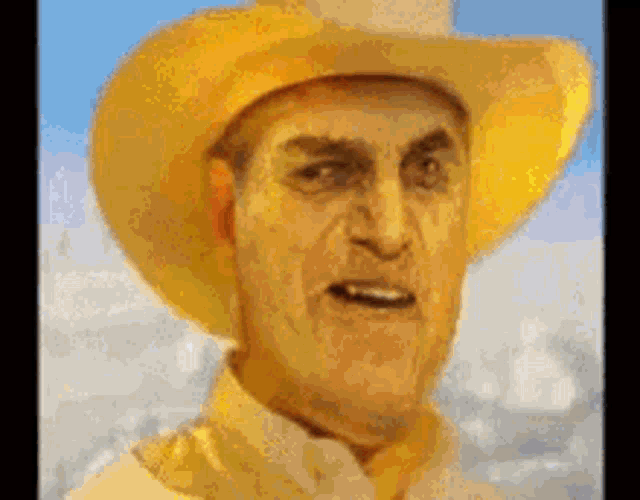 a man wearing a yellow cowboy hat and a yellow shirt .
