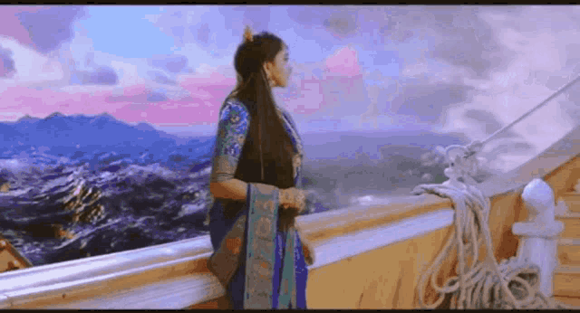 a woman standing on a balcony overlooking the ocean