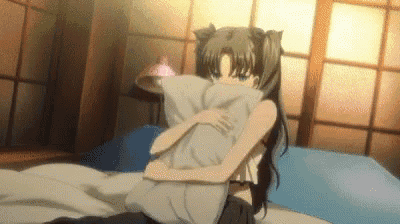 a girl is sitting on a bed holding a pillow in her hands .