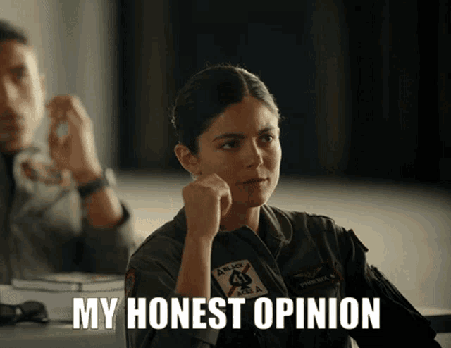 a woman in a military uniform is sitting at a table and says " my honest opinion "
