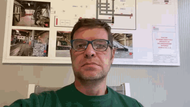 a man wearing glasses is standing upside down in front of a map that says zona s.s.s.s.