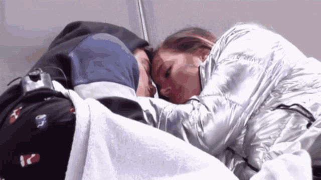 a man and a woman are laying next to each other in a bed .