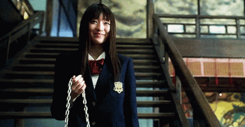 a woman in a school uniform is holding a chain while standing on stairs .