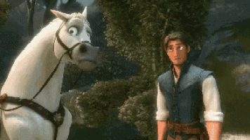 a man standing next to a white horse in a forest .