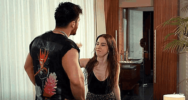 a man and woman are standing next to each other in a room .