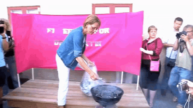 a woman is cooking food in front of a pink banner that says fi