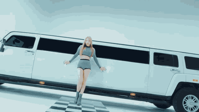 a woman is standing next to a very long white limousine