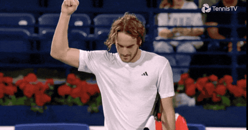 a tennis player holds his fist in the air in front of a tennis tv logo