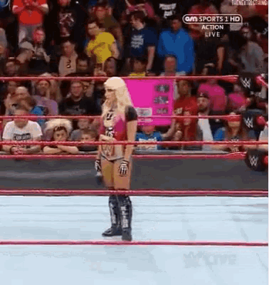 a woman in a wrestling ring with a sign that says sports 1 hd