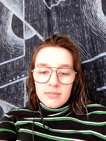 a woman wearing glasses and headphones laying down