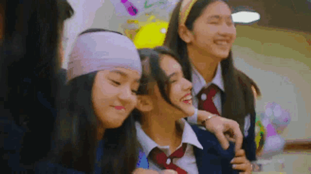 a group of girls are standing next to each other and smiling .