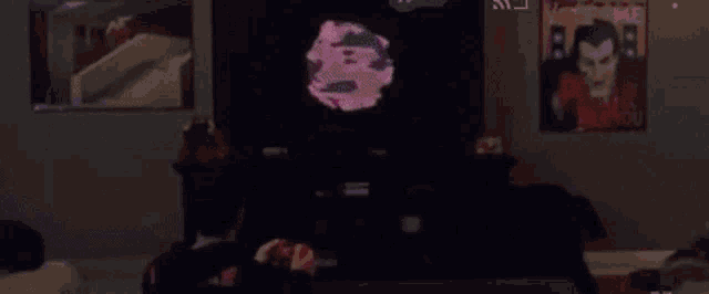 a man is playing a video game with the letter s on the screen behind him