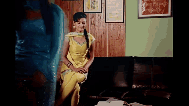 a woman in a yellow outfit sits on a couch