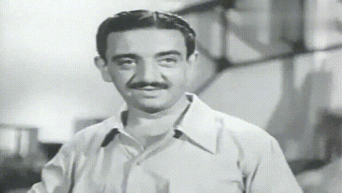 a man with a mustache is wearing a white shirt and tie