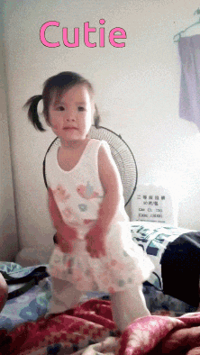 a little girl in a white dress with the word cutie on the bottom