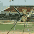 a baseball field with a stadium in the background and a few balls on the ground