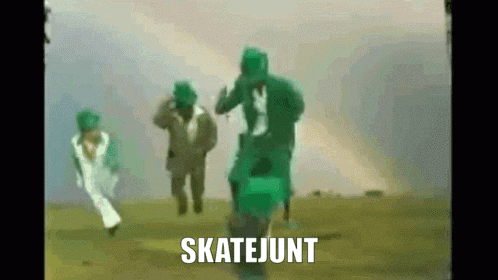 a group of people in green jumpsuits are running in a field with the word skatejutt written on the bottom