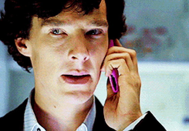 a man in a suit is talking on a cell phone