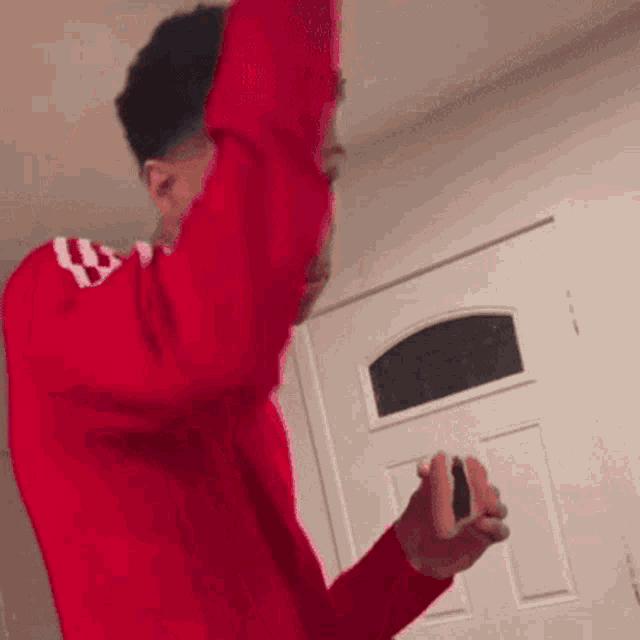 a man in a red sweater is holding a sandwich in his hands .