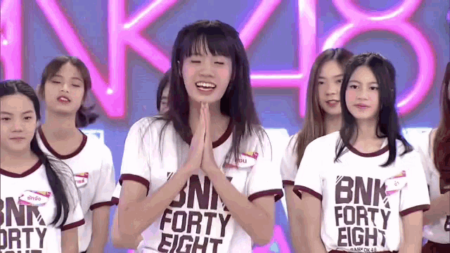 a girl wearing a white shirt that says bnk forty eight on it