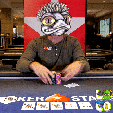 a man sitting at a poker table wearing a shirt that says poker stars on it