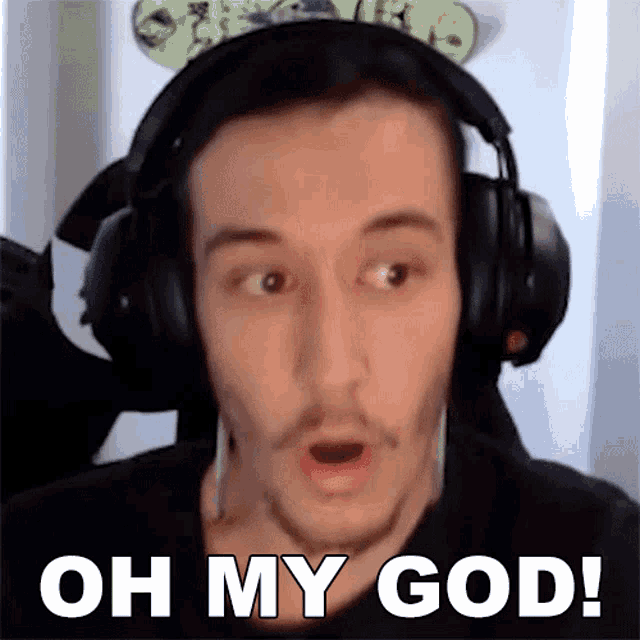 a man wearing headphones and a mickey mouse headband is making a surprised face and saying oh my god .