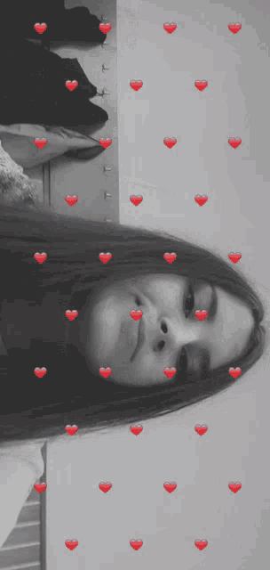 a black and white photo of a girl with red hearts on her hair