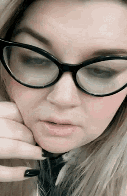 a woman wearing glasses and a tie is making a funny face