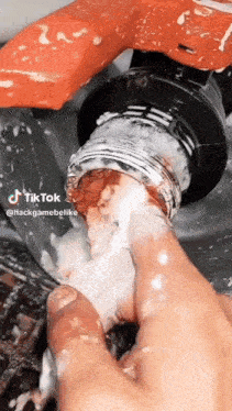 a close up of a person cleaning a faucet with their finger .